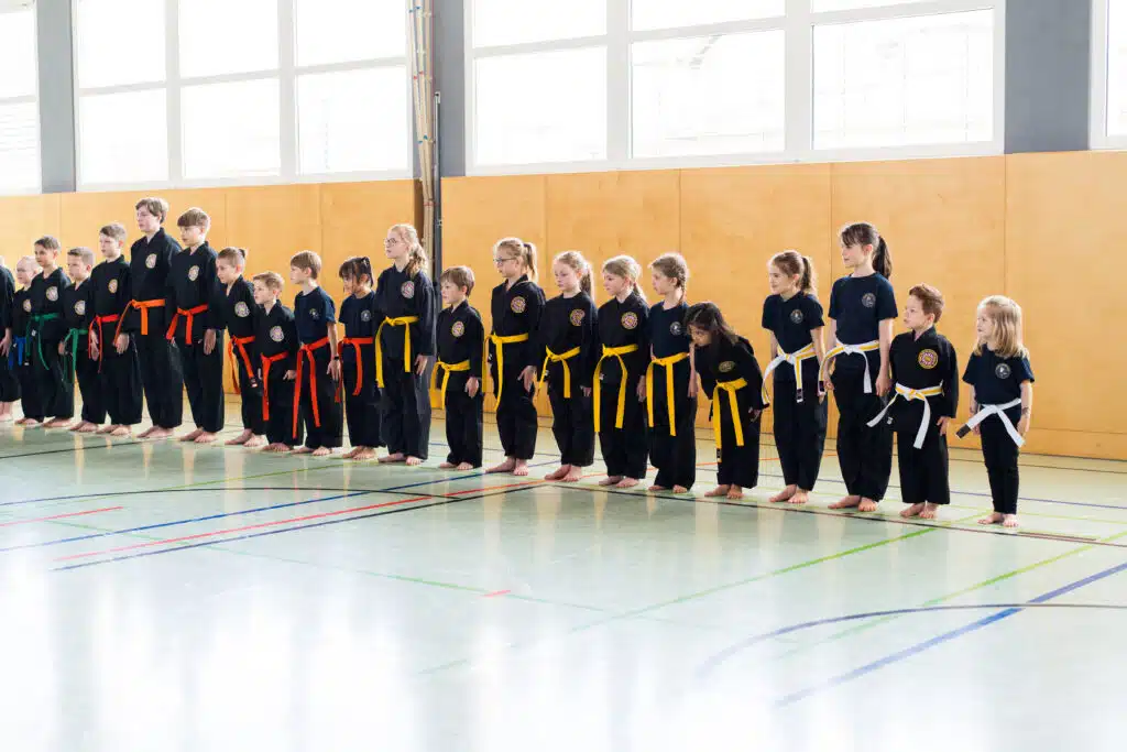 Kinder stehen in der Turnhalle in der Anfangsstellung. Disziplin